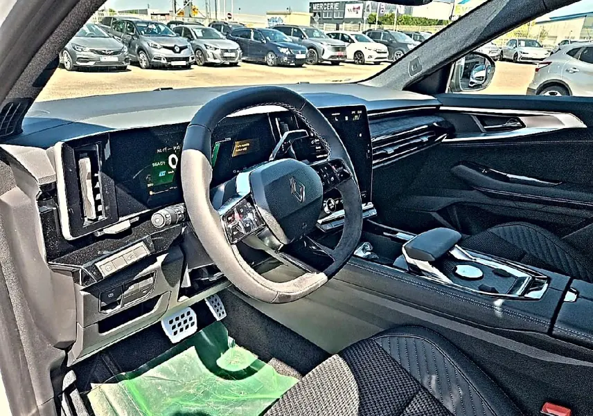 Vue intérieure côté conducteur du Renault Austral 1.2 e-tech hybride, avec volant multifonction et finition noire élégante.