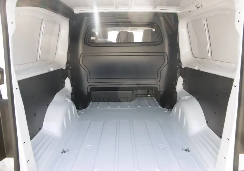 Vue intérieure de la cabine approfondie blanche du Peugeot Expert Long 2023, montrant l'espace de chargement vide.