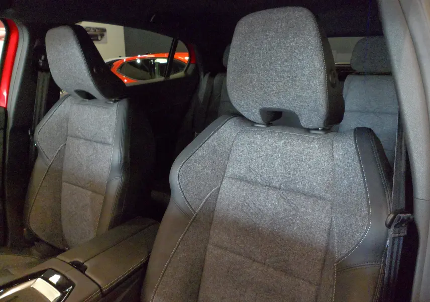 Gros plan sur les sièges avant en tissu gris avec surpiqûres noires du Renault Rafale E-Tech 2025, intérieur moderne.