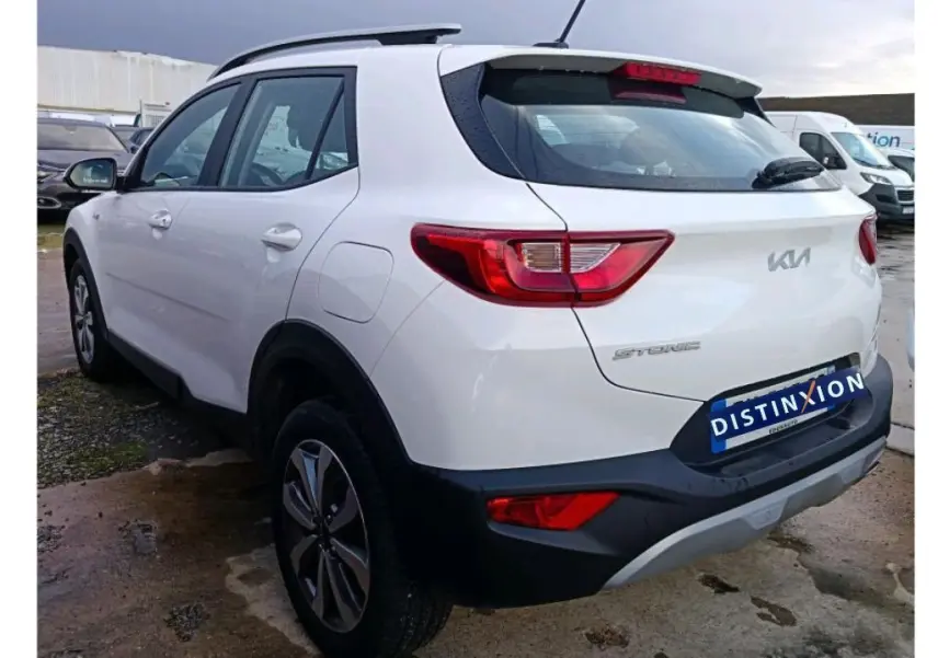 Vue 3/4 arrière droite d’un KIA STONIC blanc 2022 avec feux arrière distinctifs et logo moderne sur le hayon.