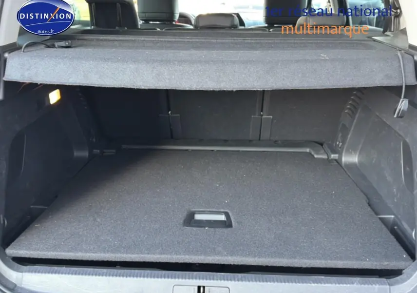 Coffre ouvert vu de l'arrière d'un Citroën C5 Aircross 2025 bleu eclipse, avec cache-bagages en place.