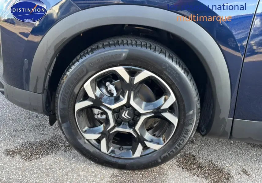 Gros plan sur la roue avant gauche du Citroën C5 Aircross bleu eclipse avec jante alu bicolore.