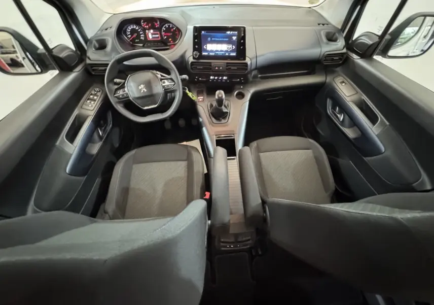 Vue intérieure avant du Peugeot Rifter BlueHDi 100 Allure 2019, tableau de bord noir avec écran tactile central et volant multifonctions.