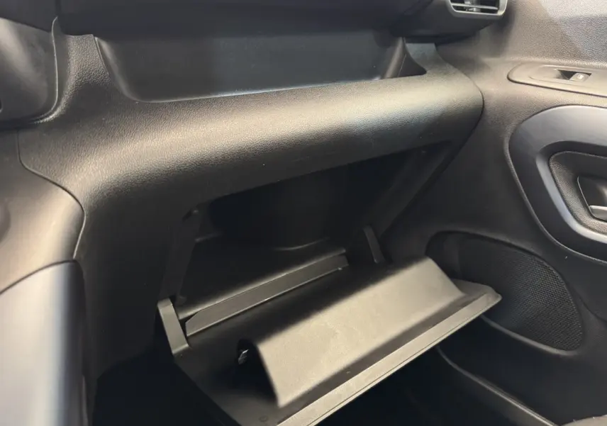 Vue intérieure côté passager du Peugeot Rifter 2019 BlueHDi 100 Allure, boîte à gants ouverte, tableau de bord noir.