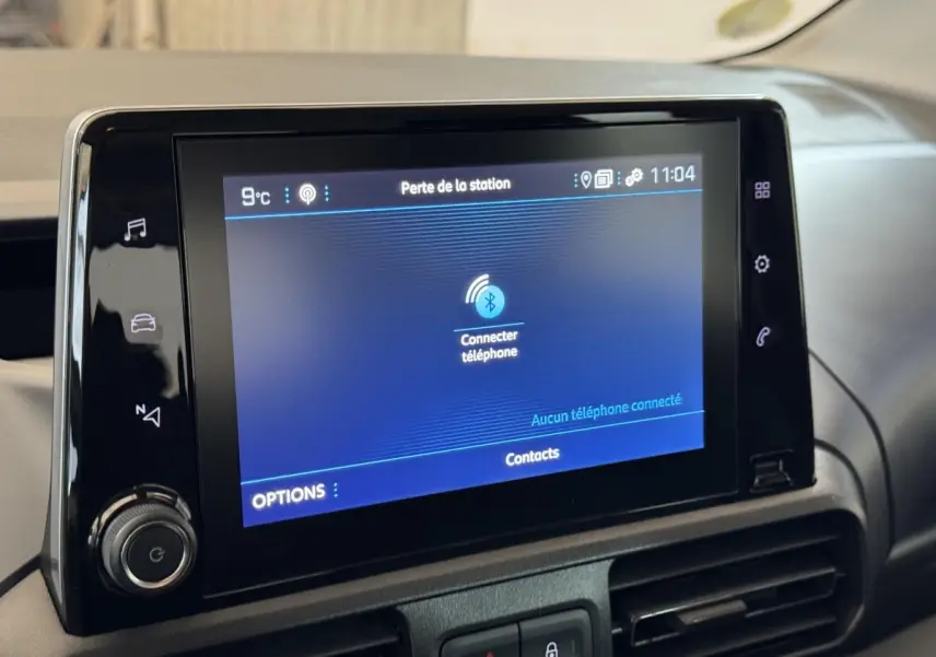 Écran tactile central du tableau de bord du Peugeot Rifter blanc, affichant la connexion Bluetooth téléphone.
