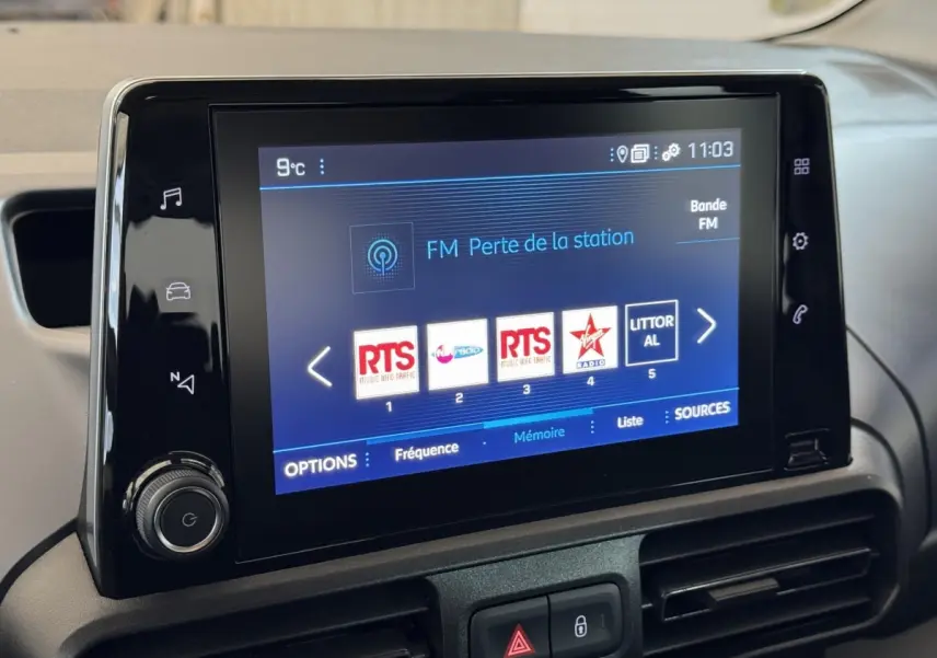 Écran tactile central du tableau de bord du Peugeot Rifter blanc, affichant les stations radio FM.