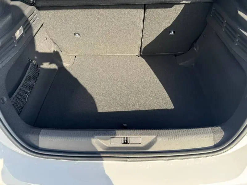 Coffre ouvert vu de dessus d’une Peugeot 308 blanc Okénite, montrant un espace de chargement propre et vide.