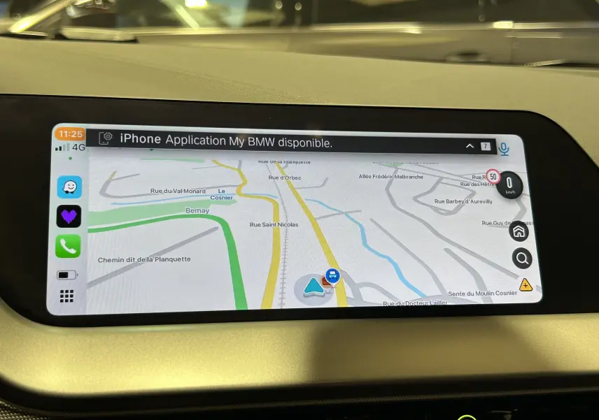 Écran GPS tactile affichant une carte de navigation dans l'habitacle beige d'une BMW Série 1 noire 2023.