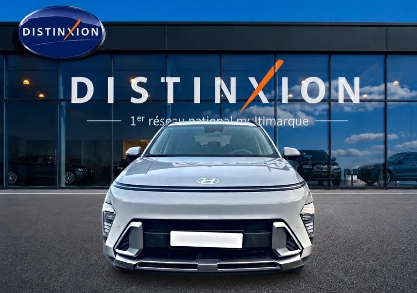 Vue frontale d'un Hyundai Kona gris 2025 avec calandre noire et bande lumineuse LED au-dessus du capot.