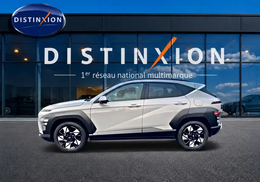 Vue latérale gauche d'un Hyundai Kona gris 2025 avec jantes alliage noires et protections d'ailes noires.
