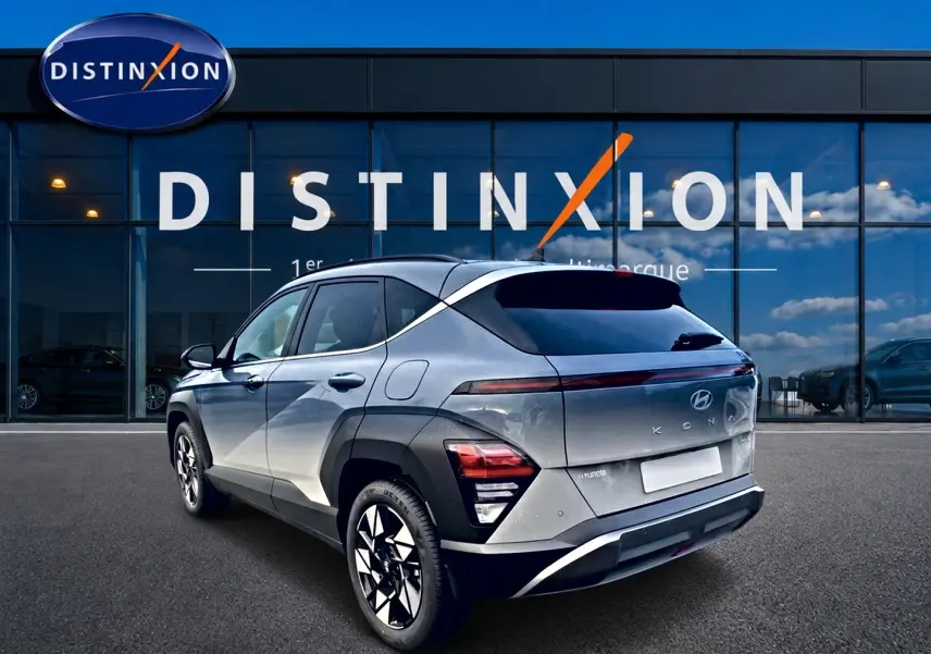 Vue 3/4 arrière droite d'un Hyundai Kona gris 2025 avec feux arrière LED et jantes alliage noires et argentées.