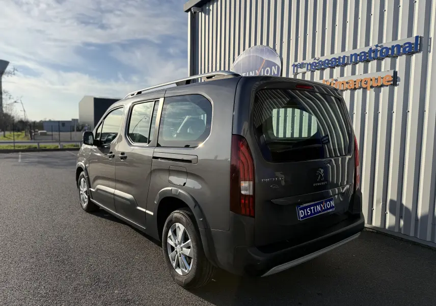Vue 3/4 arrière droite d’un Peugeot Rifter gris platinium 2020, avec hayon et vitres latérales teintées.