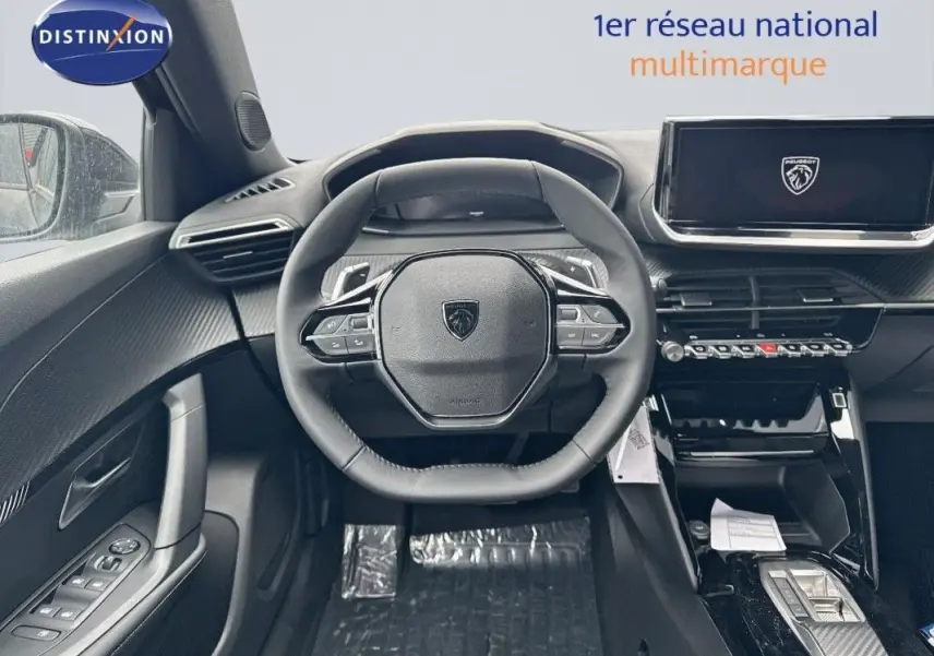 Vue intérieure centrée sur le volant cuir et l'écran tactile du Peugeot 2008 noir, avec détails modernes et commandes intégrées.