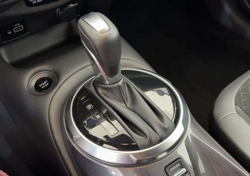 Gros plan sur le levier de vitesses automatique gris foncé du Nissan Juke 2023, avec bouton start/stop visible.