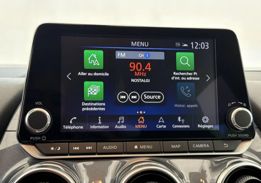 Écran tactile central du tableau de bord du Nissan Juke 2023, affichant le menu radio et navigation.