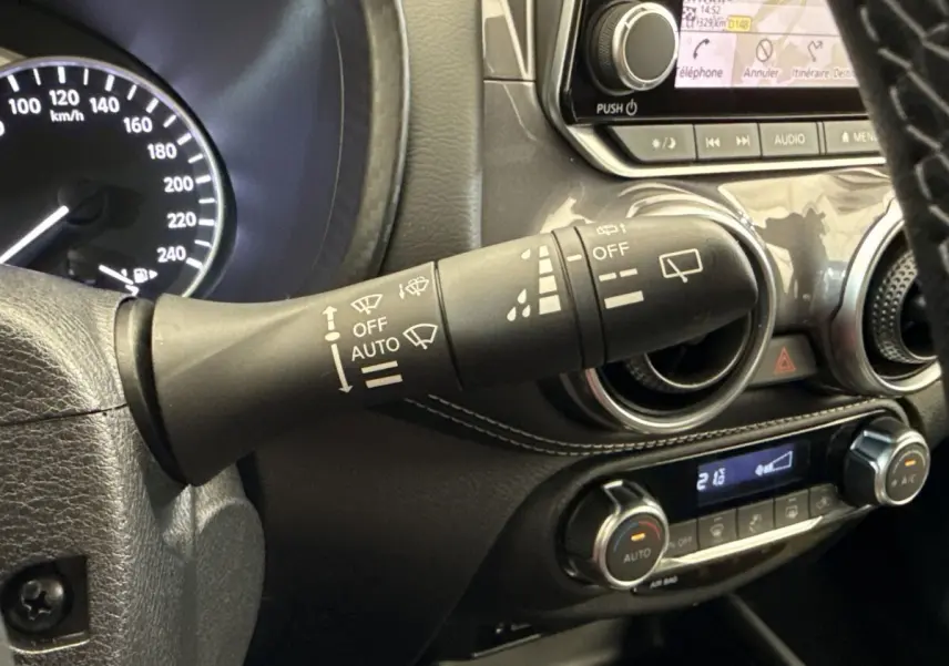 Gros plan sur la commande d’essuie-glace et le tableau de bord noir du Nissan Juke 2023 essence hybride.