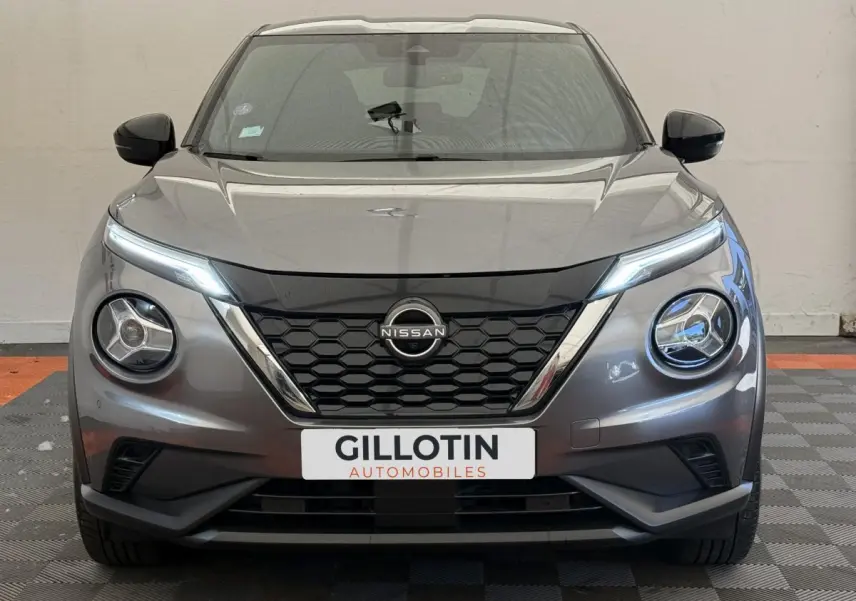 Vue frontale d’un Nissan Juke gris foncé 2023 avec phares LED et calandre noire à motifs hexagonaux.