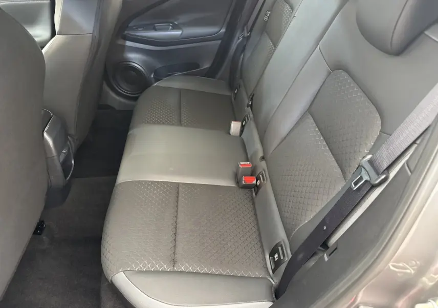 Vue intérieure côté droit montrant la banquette arrière gris foncé du Nissan Juke 2023 avec ceinture de sécurité attachée.
