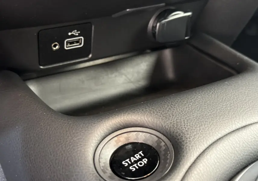 Gros plan sur le bouton Start Stop entouré d’un cerclage effet carbone dans l’habitacle du Nissan Juke 2023.