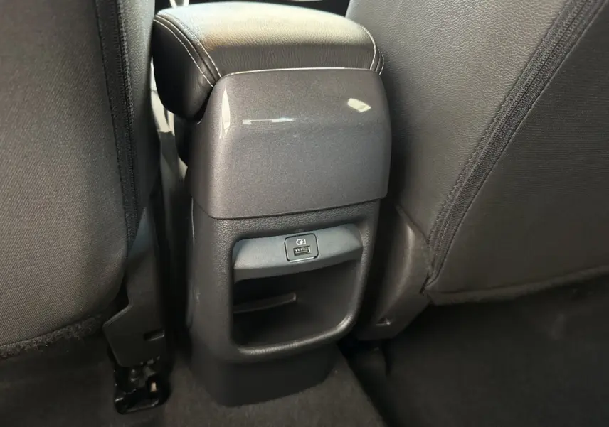 Vue rapprochée de la console arrière entre les sièges noirs du Nissan Juke 2023, avec port USB visible.