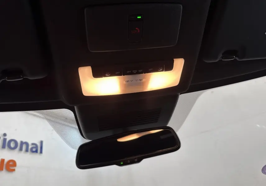 Vue intérieure du plafonnier et du rétroviseur intérieur du Nissan Juke gris foncé 2023 avec éclairage activé.