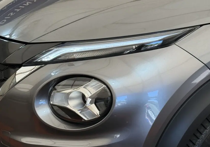 Gros plan sur le phare avant droit du Nissan Juke 2023 gris foncé, mettant en valeur son design LED distinctif.