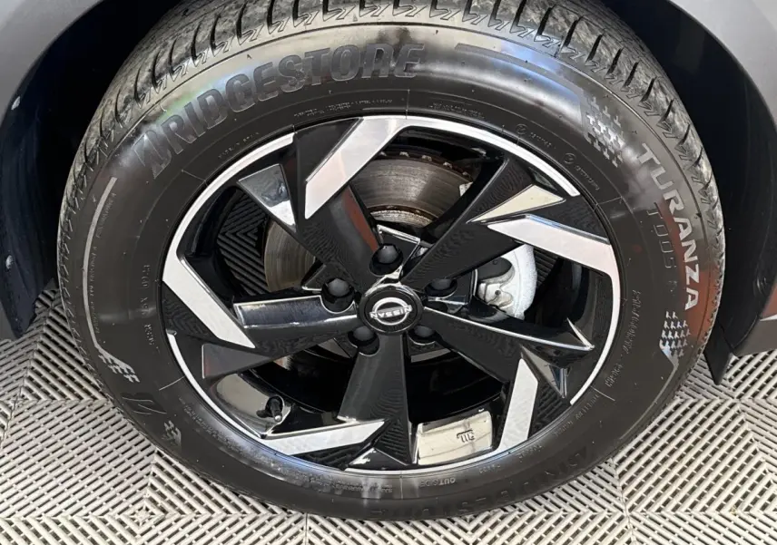 Gros plan sur la roue avant droite du Nissan Juke 2023, jante alliage noire et argent avec pneu Bridgestone Turanza.