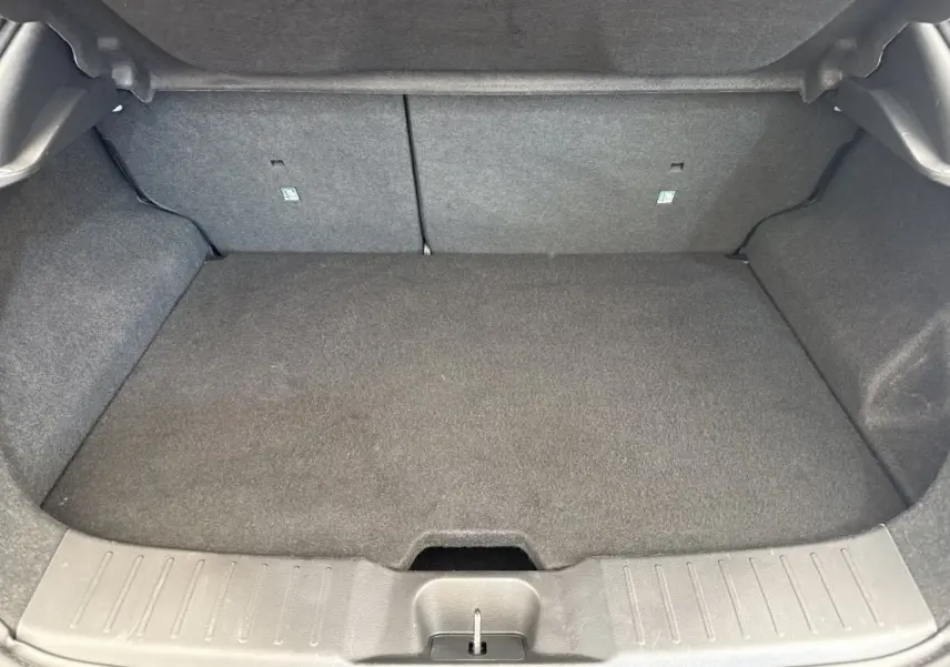 Coffre spacieux gris foncé du Nissan Juke 2023, vue intérieure arrière avec banquette rabattue et plancher plat.