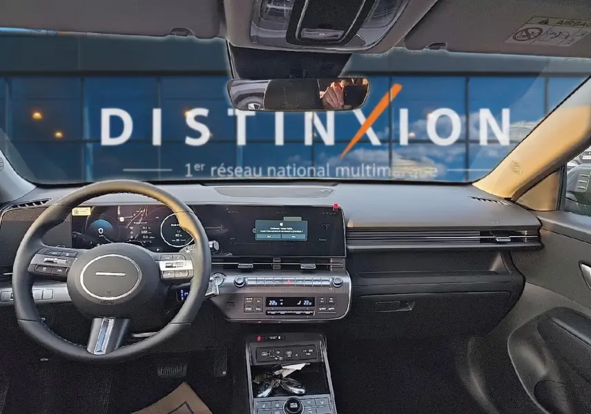 Vue intérieure avant du Hyundai Kona 2025 gris ecotronic avec tableau de bord numérique et volant multifonction cuir.