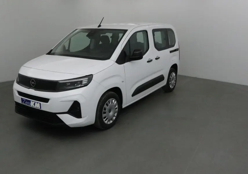 Opel Combo Life blanc en vue 3/4 avant droit, avec baguettes latérales noires et jantes acier d'origine.