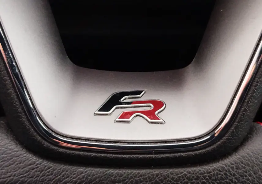 Gros plan sur le logo FR bicolore noir et rouge sur le volant d'une SEAT ARONA 2020 finition FR.