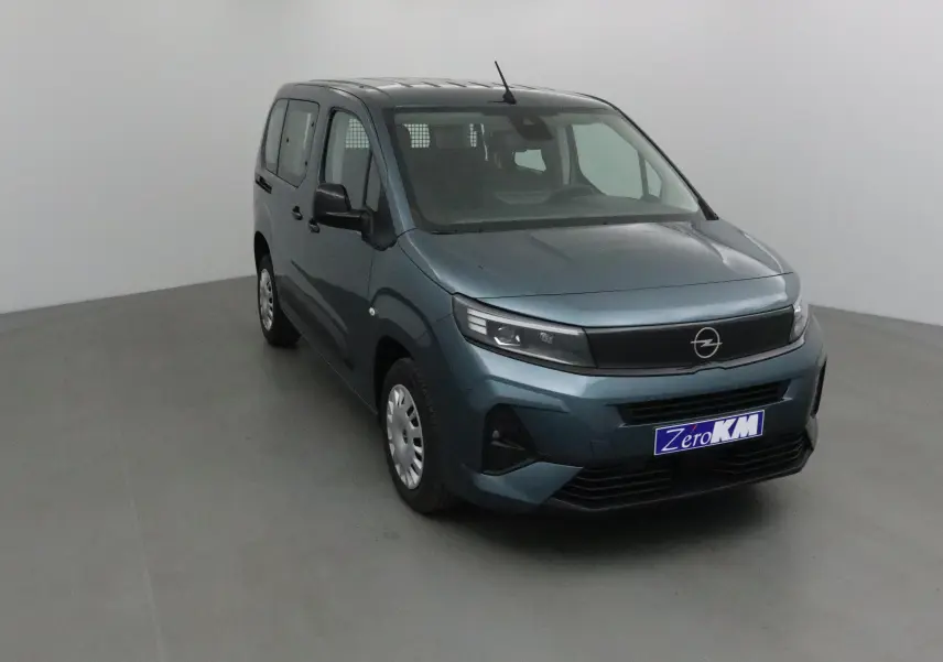 Vue 3/4 avant d'un Opel Combo Life bleu Kiama avec calandre noire et plaque Zero KM dans un studio.