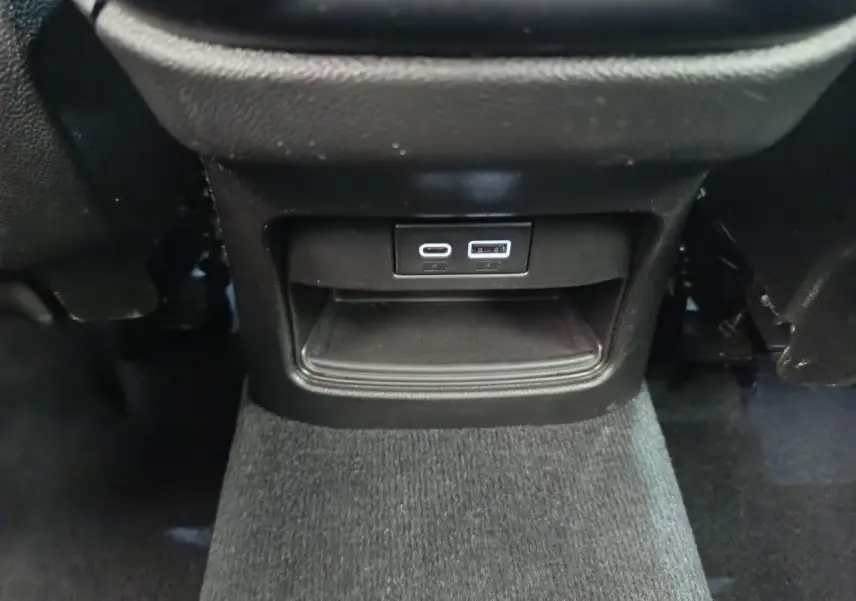 Prise USB type C et USB standard en bas de la console centrale noire de l'Alfa Romeo Stelvio Sprint 2024.