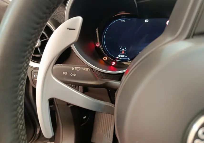 Gros plan sur le volant et le combiné d'instruments digital de l'Alfa Romeo Stelvio gris foncé, côté conducteur.