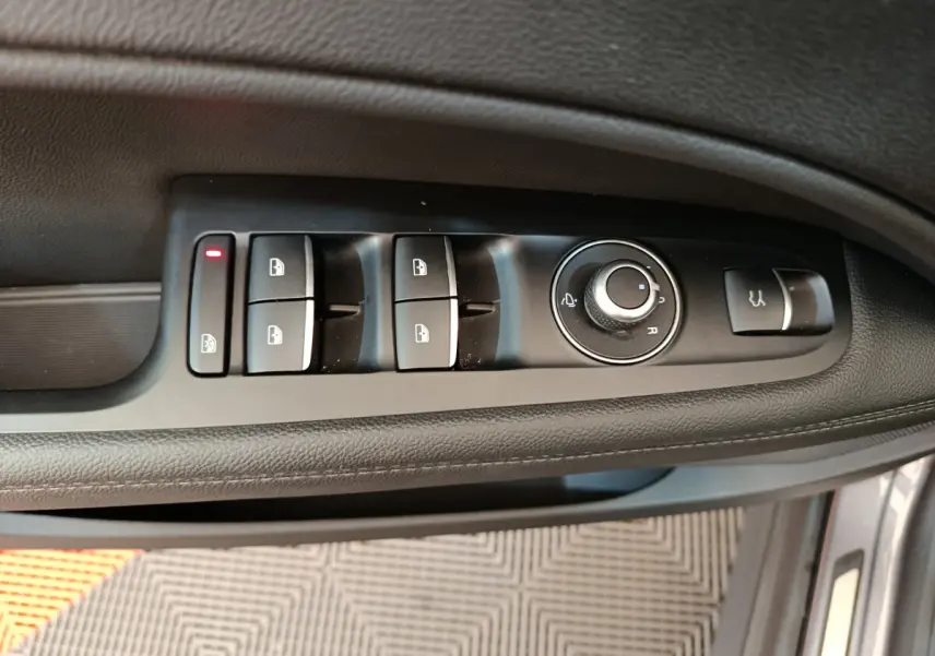 Panneau de commandes des vitres et rétroviseurs côté conducteur de l'Alfa Romeo Stelvio gris foncé 2024.