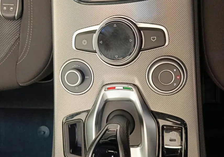 Vue plongeante sur la console centrale gris foncé de l'Alfa Romeo Stelvio 2.2 TD 160 AT8 Sprint avec levier de vitesses automatique.
