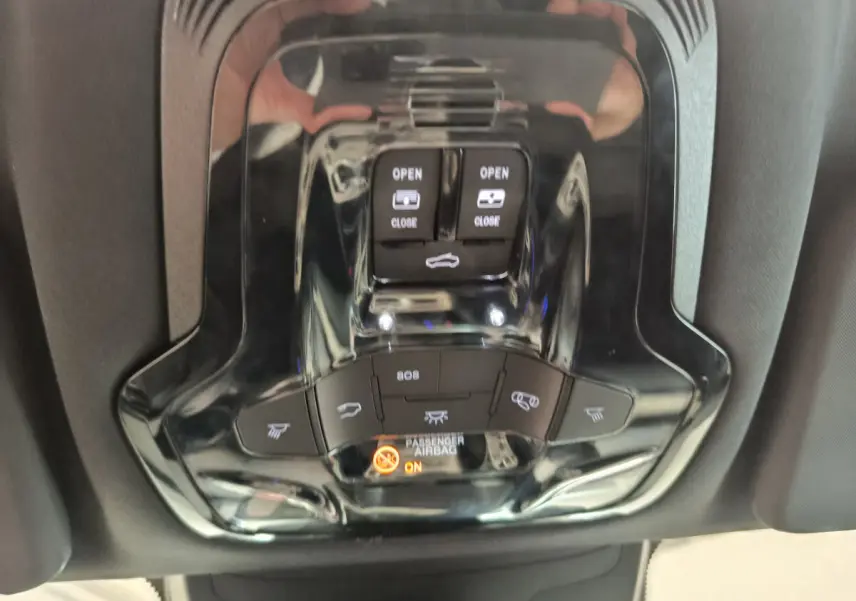 Vue rapprochée du panneau de commandes de toit ouvrant et éclairage intérieur noir brillant dans un Alfa Romeo Stelvio gris foncé 2024.