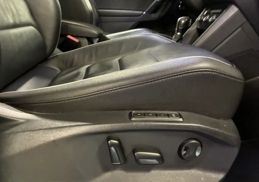 Gros plan sur le siège conducteur en cuir noir avec réglages électriques et mémoire dans le Volkswagen Tiguan gris 2017.