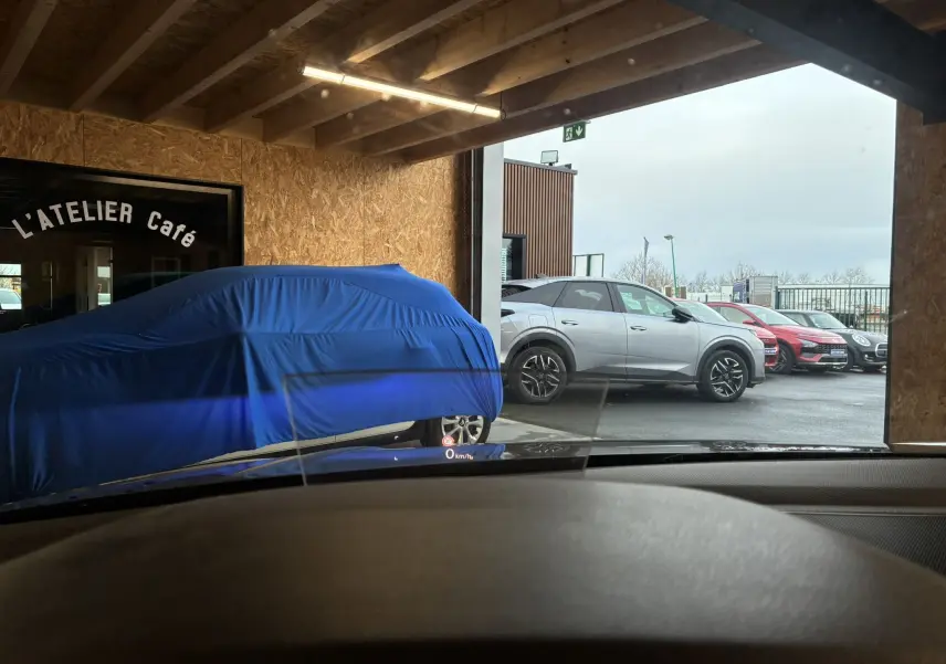 Vue latérale droite d'un Volkswagen Tiguan gris stationné à l'extérieur, avec jantes noires et toit noir contrastant.