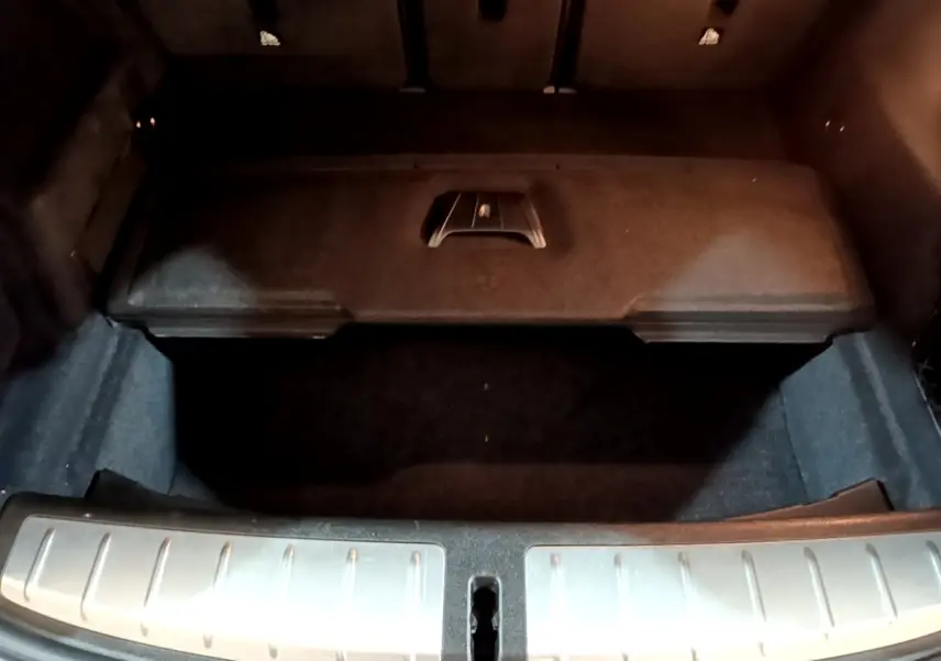 Coffre ouvert vu de dessus d’un BMW X2 gris foncé avec seuil de chargement en métal brossé.