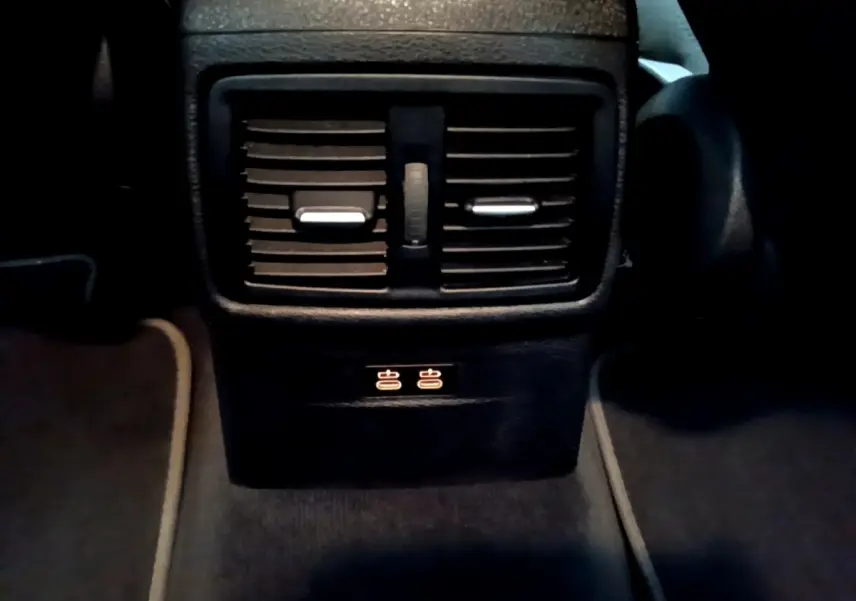 Vue rapprochée des aérateurs arrière noirs et commandes de ventilation pour sièges passagers du BMW X2 gris foncé.