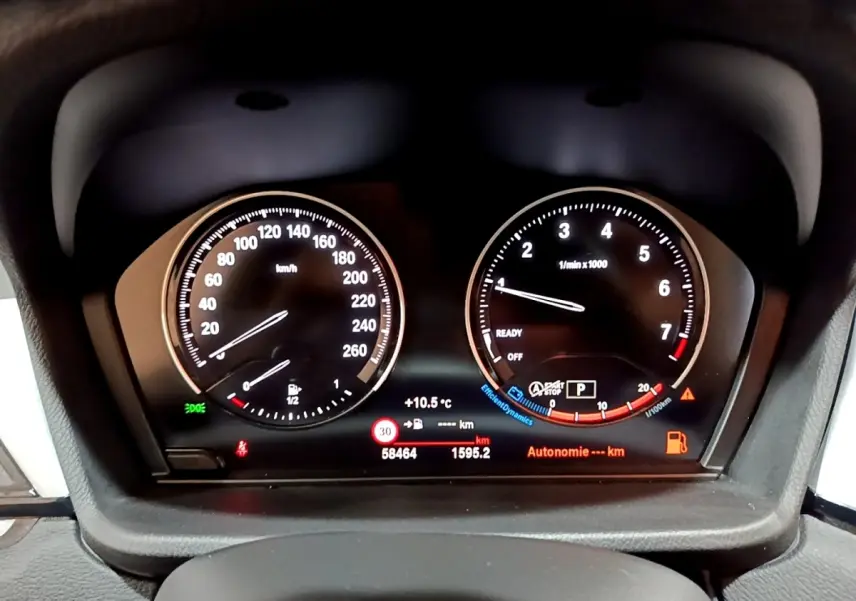 Tableau de bord BMW X2 sDrive18i 2021, vue frontale sur compteur vitesse et compte-tours lumineux.