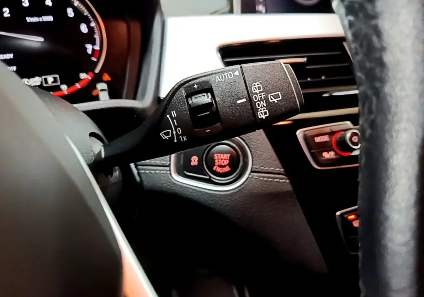 Gros plan sur la commande d’essuie-glace et le bouton start/stop du tableau de bord d’une BMW X2 2021.