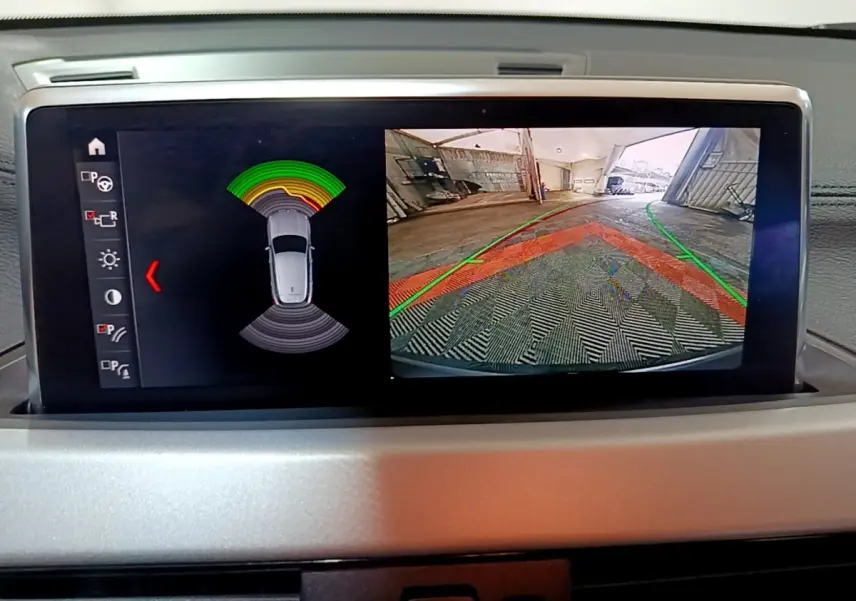 Affichage écran intérieur BMW X2 sDrive18i 2021 montrant caméra de recul et capteurs de stationnement.