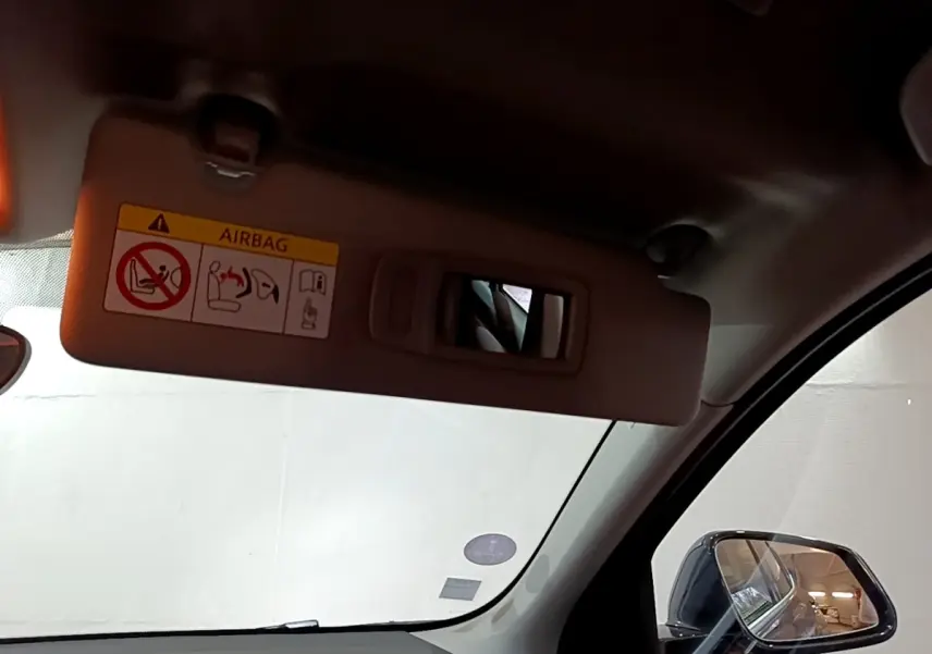 Détail du pare-soleil côté conducteur avec miroir intégré et rétroviseur extérieur noir d'une BMW X2 gris foncé.