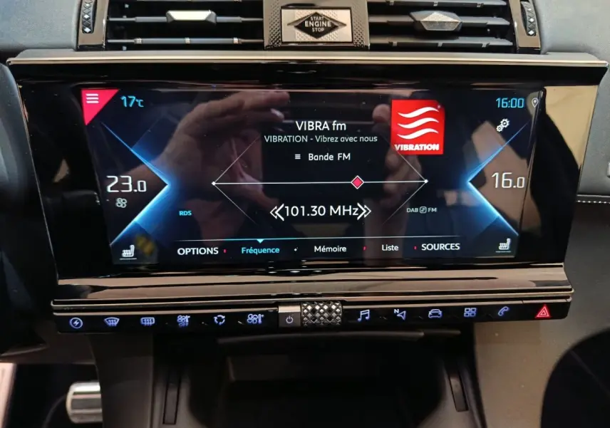 Vue rapprochée de l’écran tactile central noir du DS7 Crossback E-TENSE 4x4 300, affichant la radio FM et la climatisation.