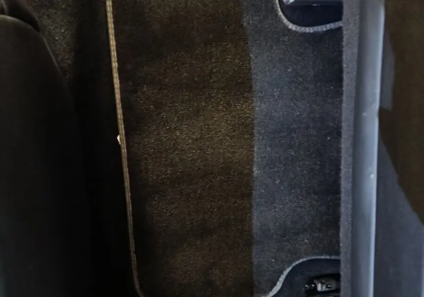 Vue rapprochée du tapis de sol arrière noir du DS7 Crossback E-TENSE 4x4 300 LOUVRE, avec partie de l'assise visible.