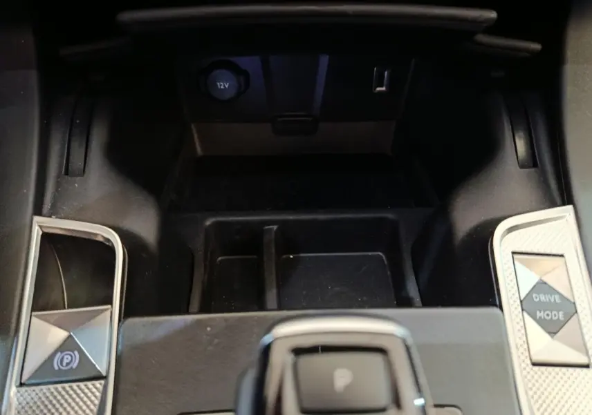 Gros plan sur la console centrale noire du DS7 Crossback E-TENSE avec boutons frein à main et mode de conduite.