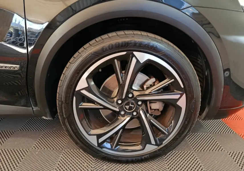 Gros plan sur la roue avant droite noire du DS7 Crossback E-TENSE 4x4 300 LOUVRE avec jante alliage bicolore.