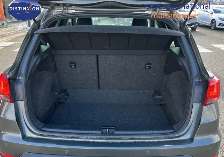 Coffre ouvert vu de l'arrière d'un SEAT Arona gris magnétique, montrant l'espace de chargement vide et la tablette cache-bagages.